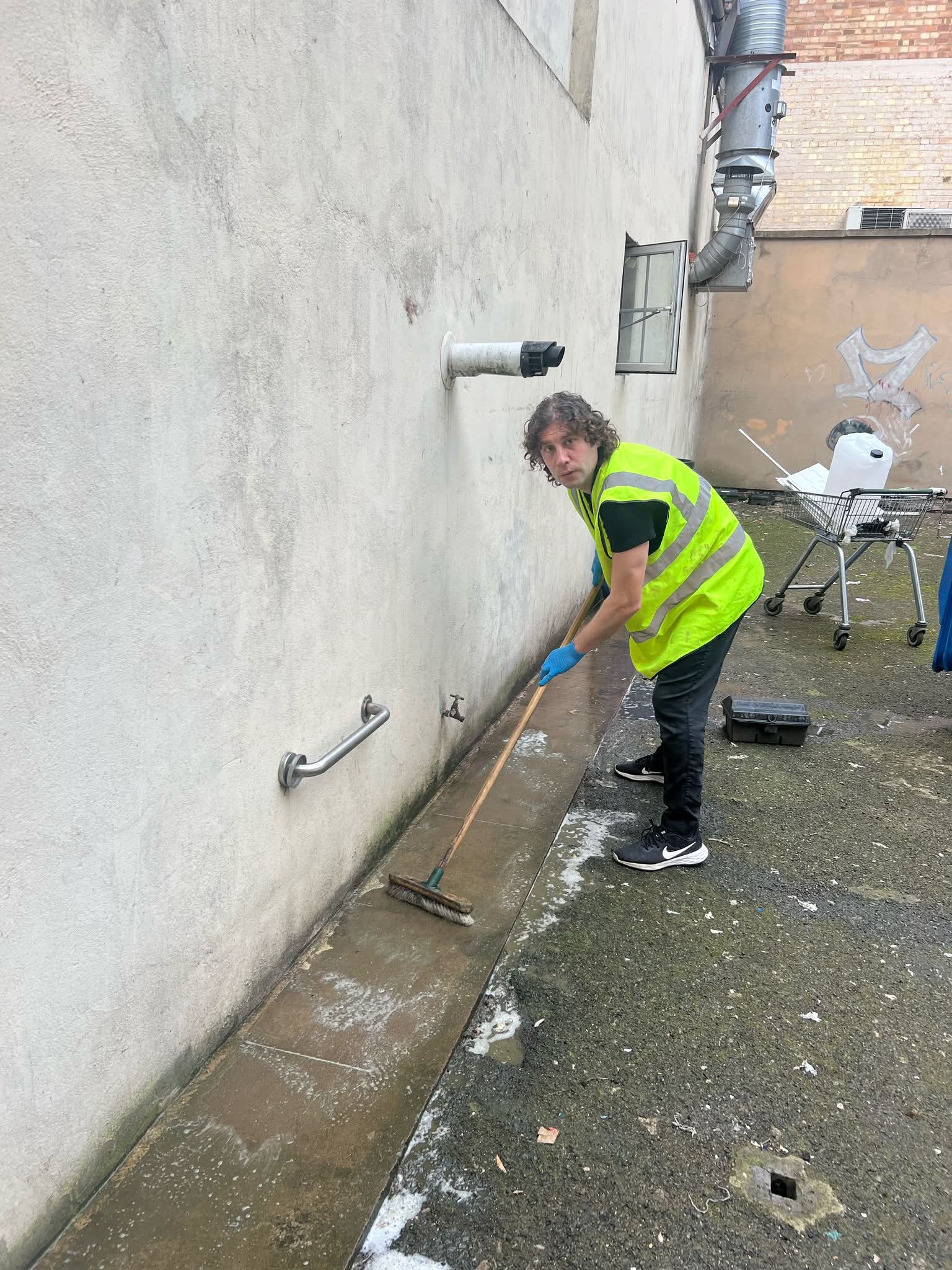 Scrubbing paving alongside a commercial building